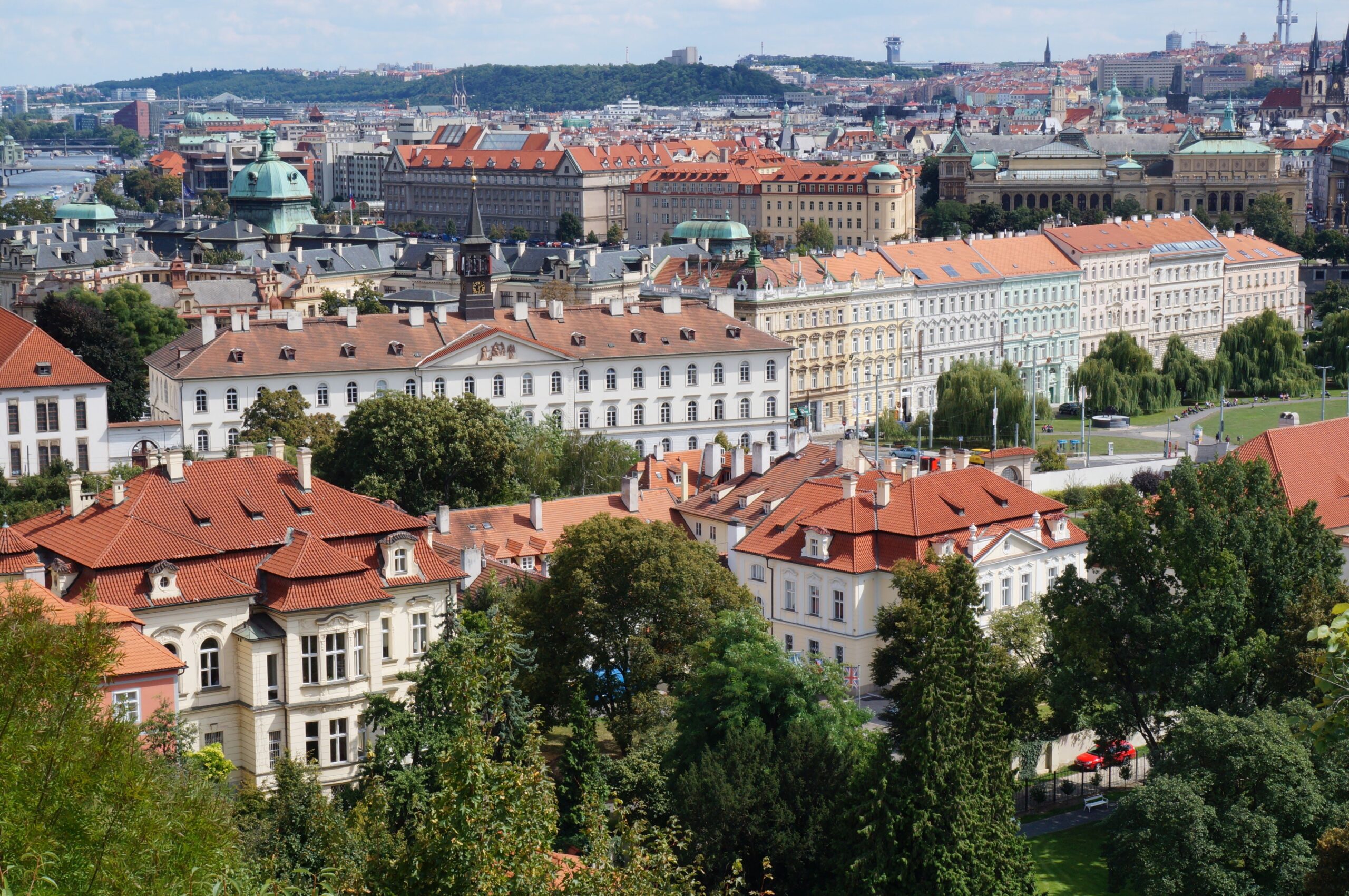 Historic Prague rooftops and skyline beneath a bright sky