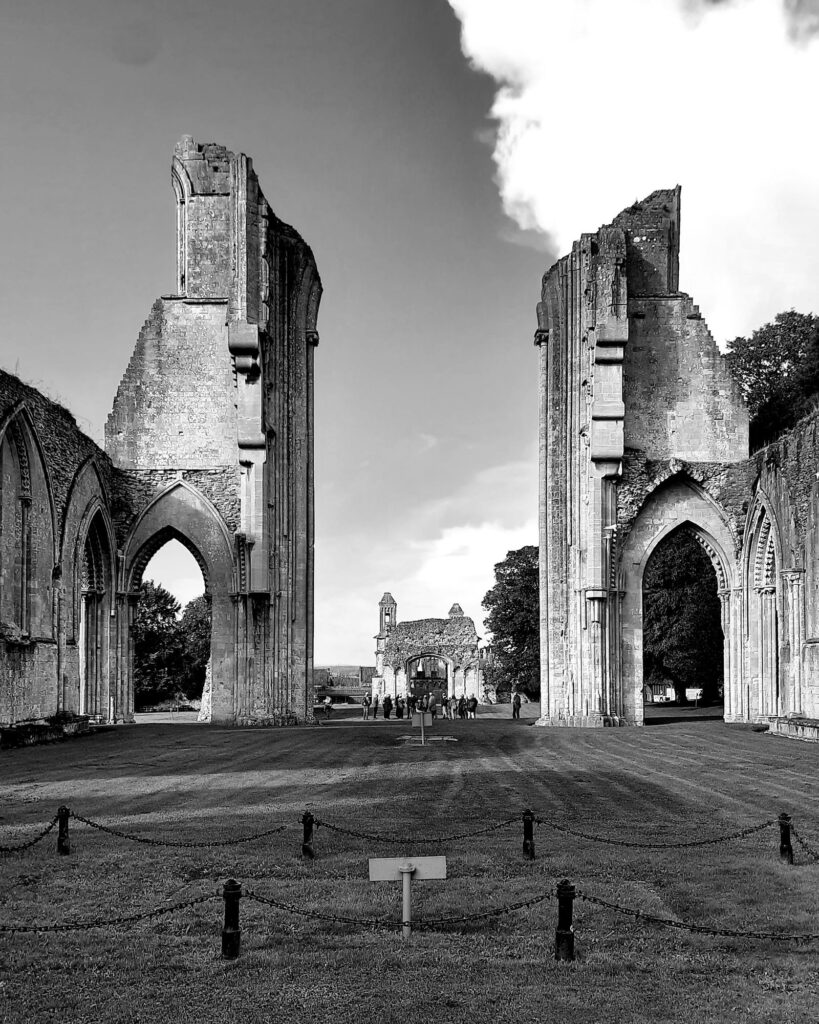 Black and white view of the stone arches and ruins of Glastonbury Abbey