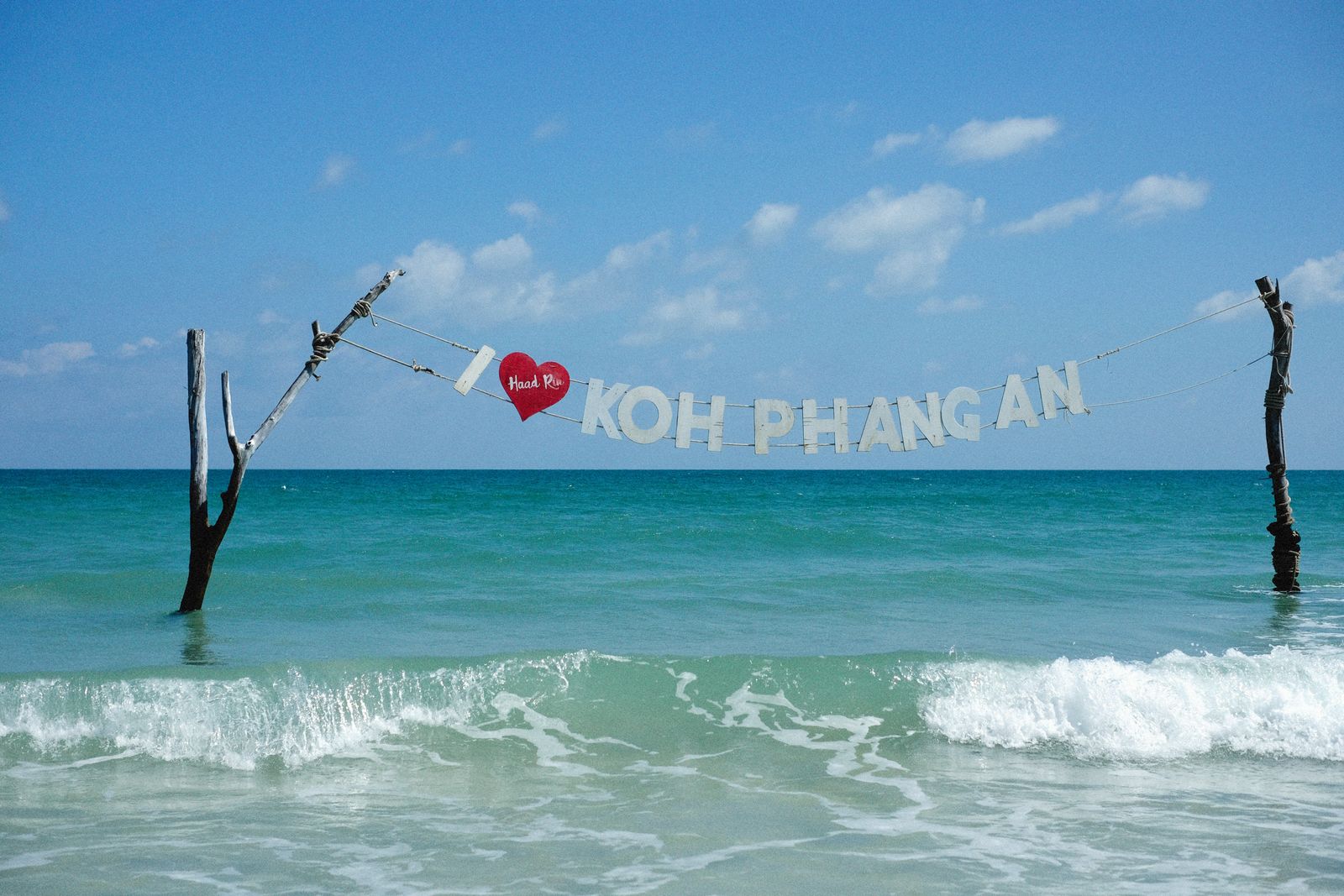 Haad Rin Koh Phangan sign above turquoise waves at the beach