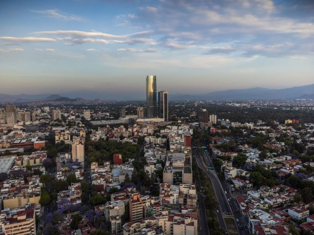 Mexico City skyline with a tall glass tower and surrounding neighbourhoods