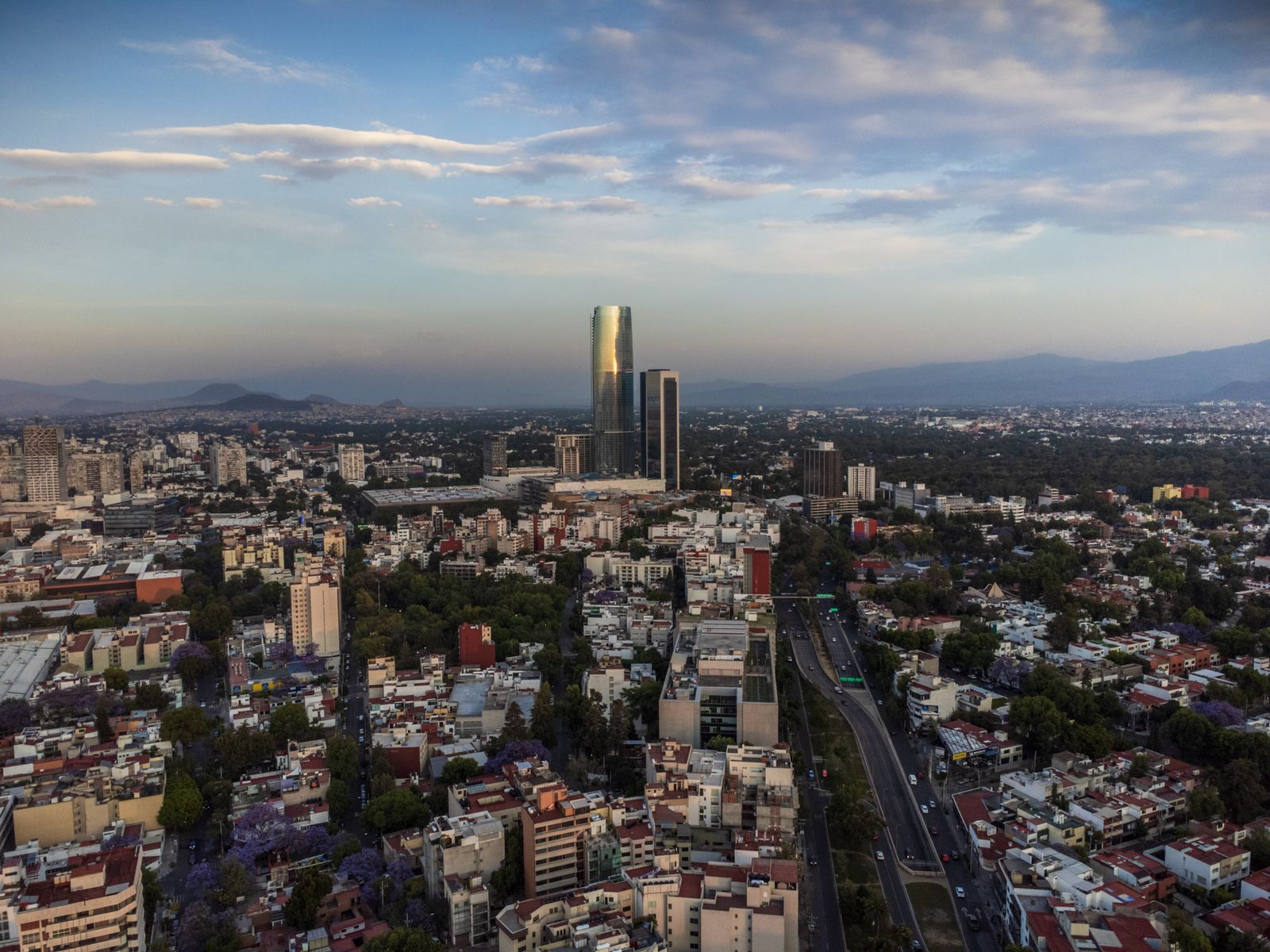 Mexico City skyline with a tall glass tower and surrounding neighbourhoods